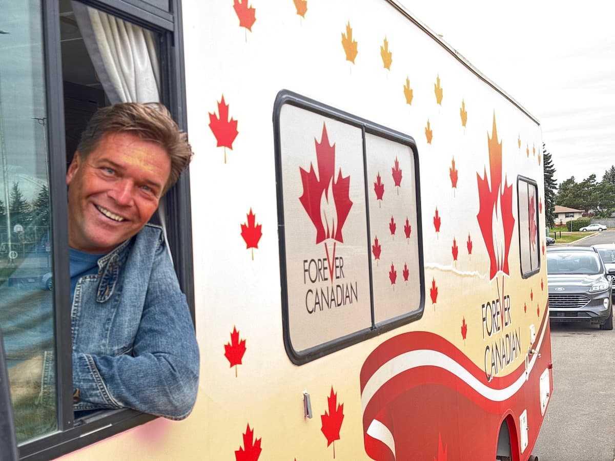 Thomas speaking in a red vest